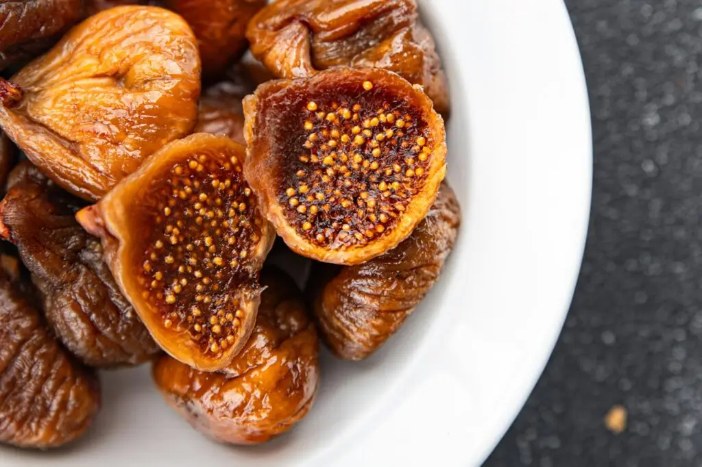 תאנים מיובשים בצלחת לבנה על שולחן