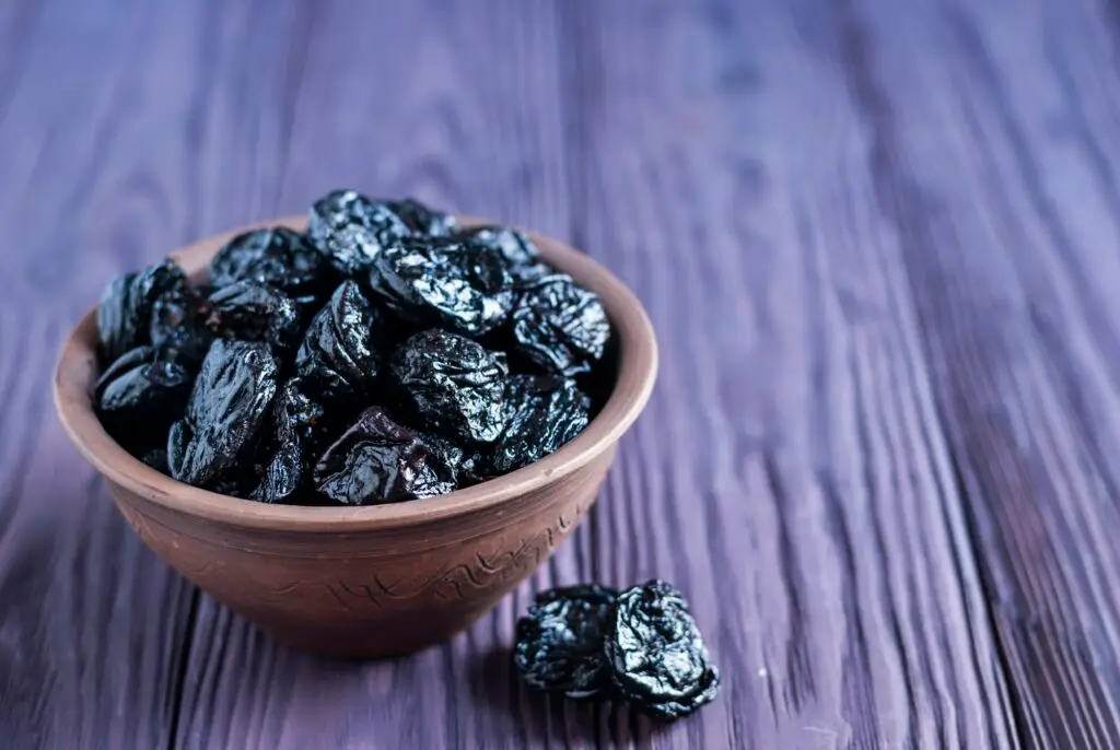 ערימה של שזיפים מיובשים עסיסיים בקערה