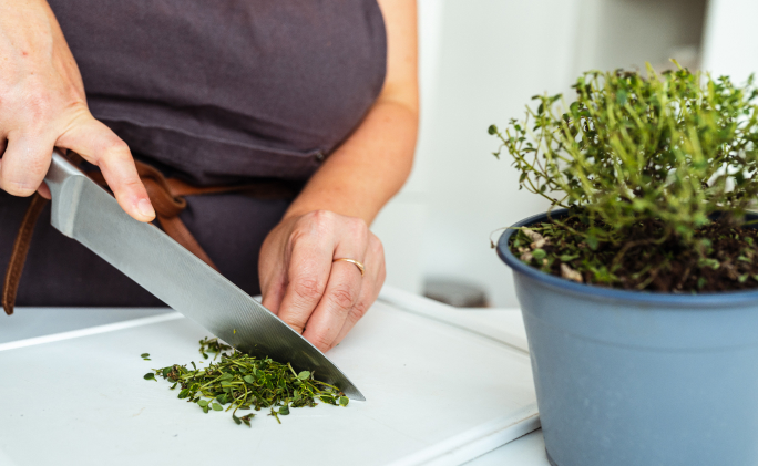 אישה חותכת עם סכין טימין על קרש לבן