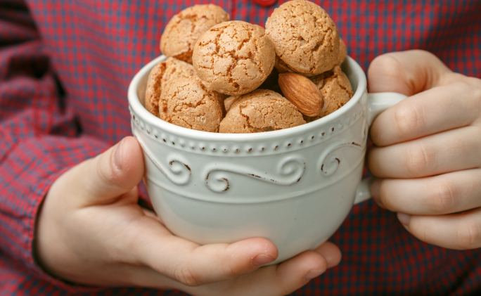 אדם מחזיק קערת עוגיות שקדים