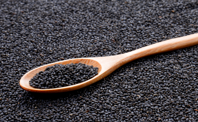 תצלום תקריב של זרעי קצח על כף עץ